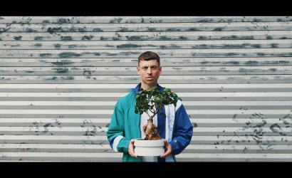 Ein Mann der eine Pflanze mit Topf in den Händen hält